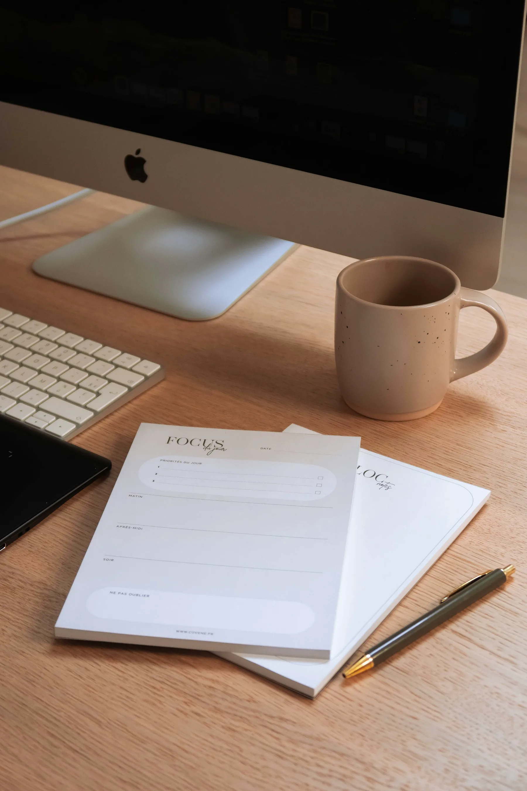 A notebook and coffee on a desk