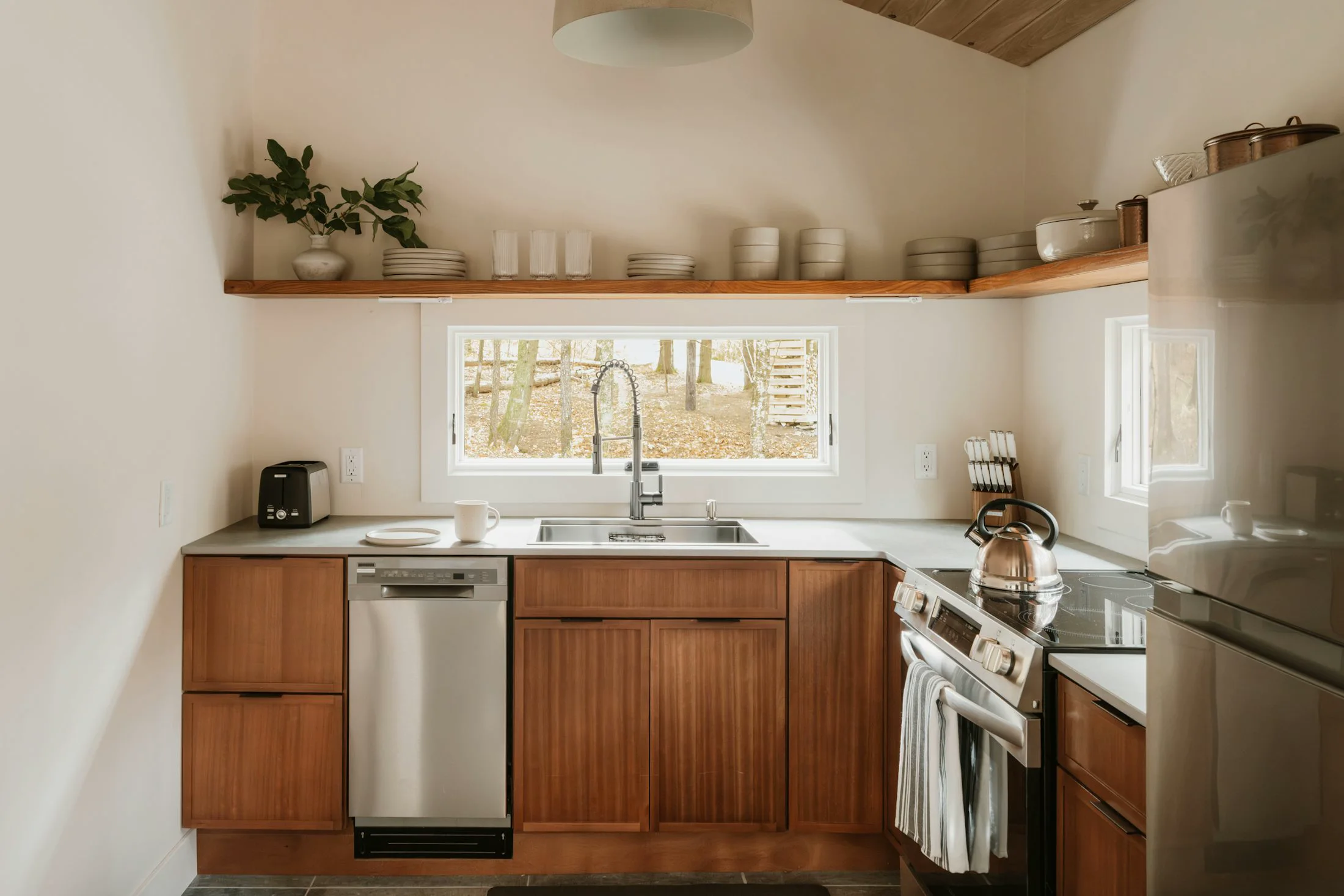 Timber kitchen cabinets beneath open shelves and a long worktop