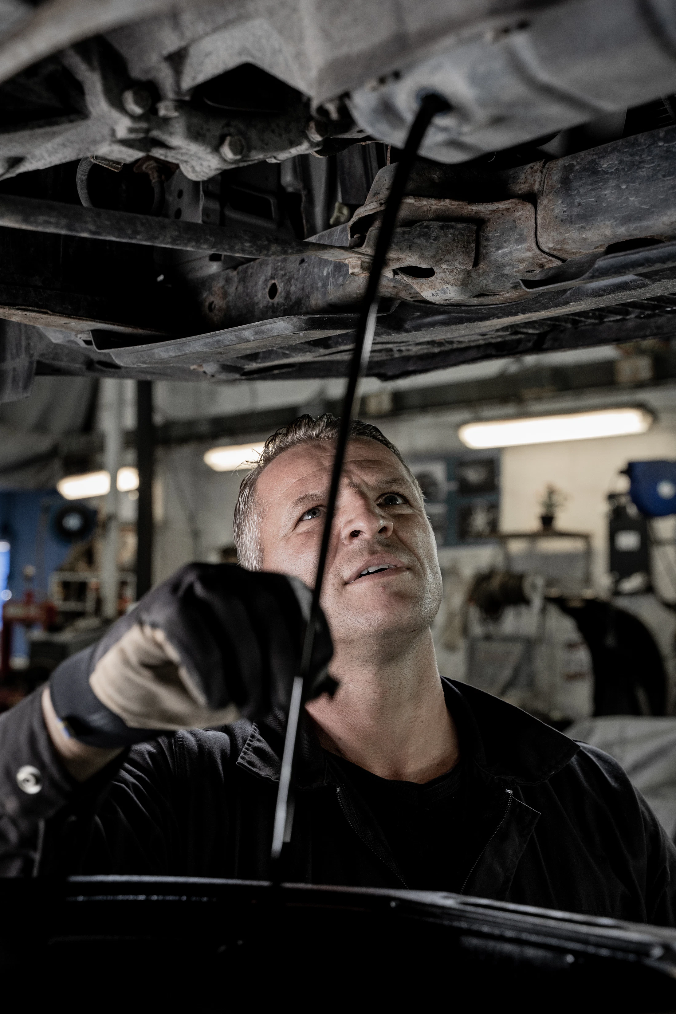 Mechanic working beneath a car in a garage