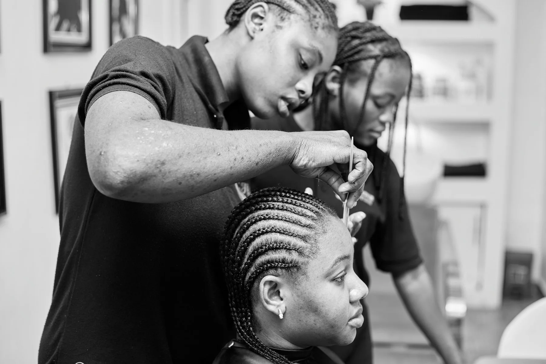 A stylist braiding long hair