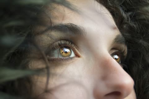 A close portrait showing one eye through loose strands of hair